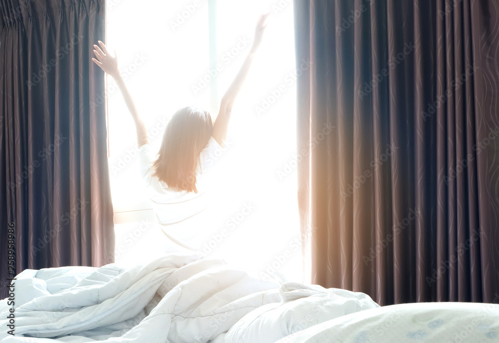 Morning of a new day, alarm clock wake up man sitting in the room. A man stretch the muscles at window. Health and care concepts Morning of a new day, alarm clock wake up man sitting in the room. A man stretch the muscles at window. Health and care concepts