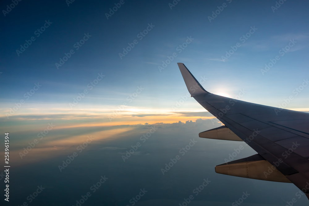 wing of an airplane flying above the clouds wing of an airplane flying above the clouds