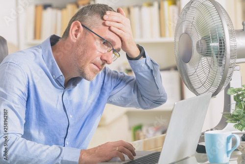 Man suffers from heat in the office or at home