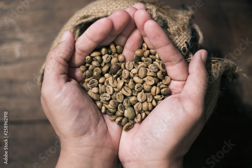 Coffee beans in the hands of heart shaped.