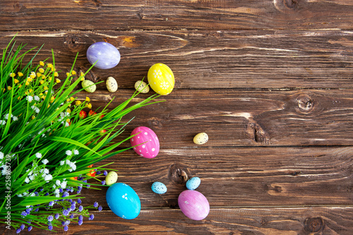 Hand-painted easter eggs with tulips on wooden background