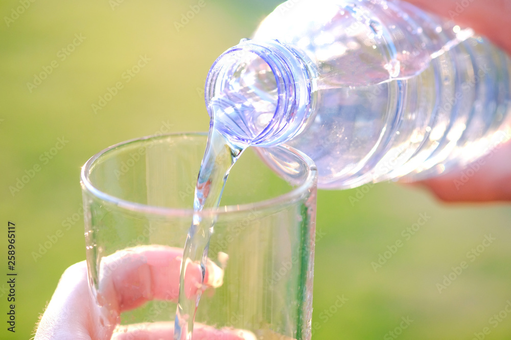 Pour pure water from a bottle of mineral water into a glass.Health concept Pour pure water from a bottle of mineral water into a glass.Health concept