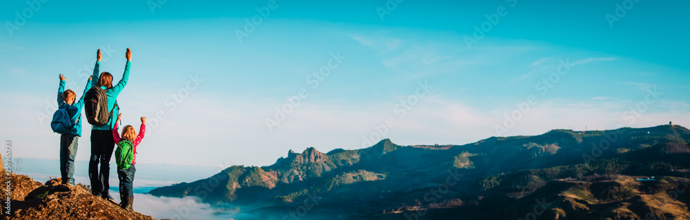 happy mother and kids hiking in mountains, family travel in nature