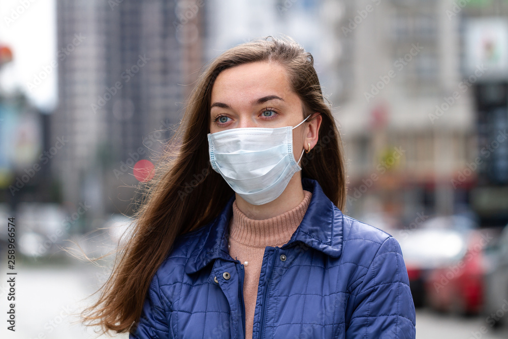 Woman in mask on street because of air pollution and epidemic in city. Protection against virus, infection, exhaust and industrial emissions Woman in mask on street because of air pollution and epidemic in city. Protection against virus, infection, exhaust and industrial emissions