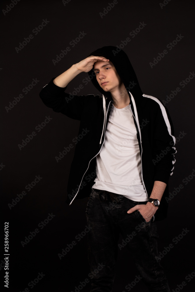 handsome young man posing on a black background looking into the distance handsome young man posing on a black background looking into the distance