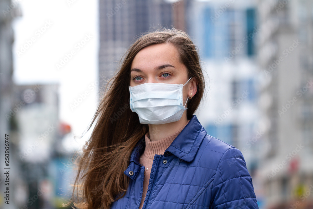 Woman in medical mask on street. Protection against virus, infection, exhaust and industrial emissions in urban. Air pollution and epidemic in city Woman in medical mask on street. Protection against virus, infection, exhaust and industrial emissions in urban. Air pollution and epidemic in city