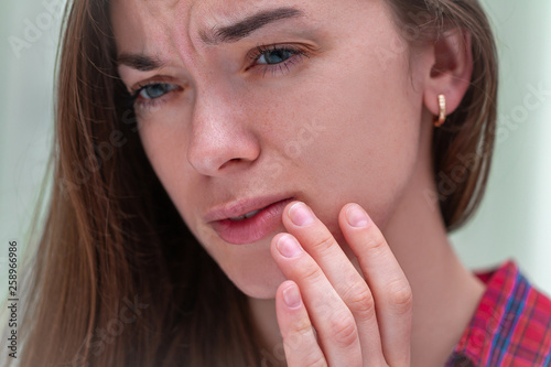 Young woman suffering from herpes on lips. Treatment of herpes infection and virus