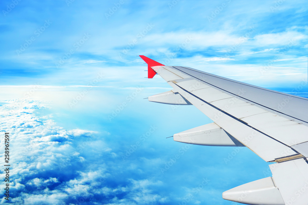 The plane flies in the afternoon over a beautiful blue sky in the afternoon: a white wing flies through the day sky, beautiful clouds The plane flies in the afternoon over a beautiful blue sky in the afternoon: a white wing flies through the day sky, beautiful clouds