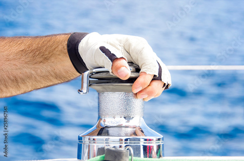 Aparejo y mano con guante mitón de barco velero photo