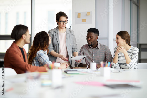 Portrait of successful female manager leading multi-ethnic team in meeting, copy space