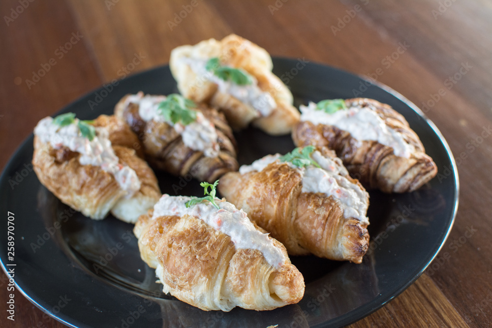 Croissant with Tuna Salad Sandwich on wood table Croissant with Tuna Salad Sandwich on wood table