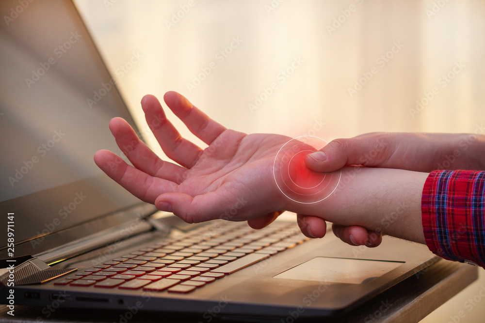 Wrist pain because of long work at laptop. Tunnel syndrome. Professional disease and hand pain