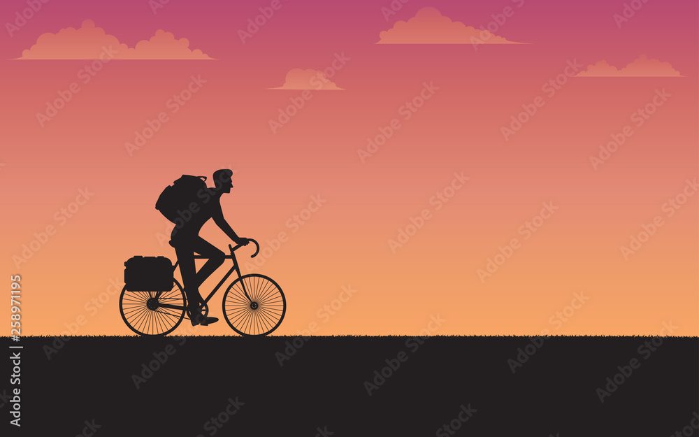 Silhouette cyclist traveler with backpack riding a bike on sunset background