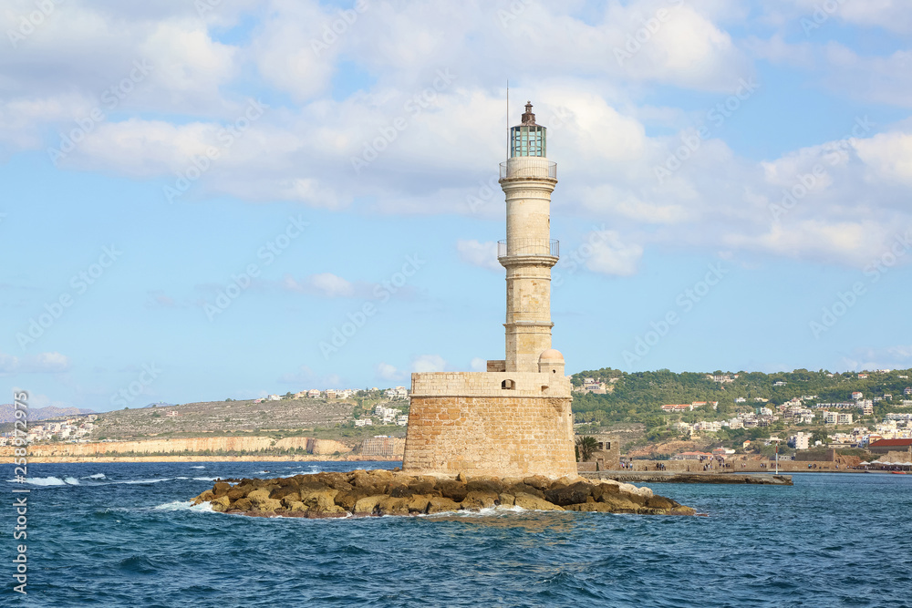  Lighthouse. Beautiful view to the rocky coast with ancient architecture. Seaport touristic town Chania, Creete island, Greece. Blue sea with waves.