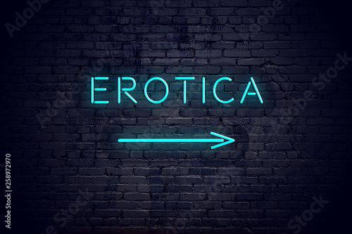 Brick wall with neon arrow and sign erotica photo