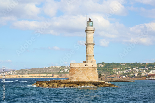  Lighthouse. Beautiful view to the rocky coast with ancient architecture. Seaport touristic town Chania, Creete island, Greece. Blue sea with waves.