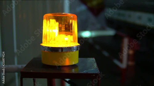 Yellow siren spinning and lighting in front of the construction site in the night time to alarm for the safety factor.