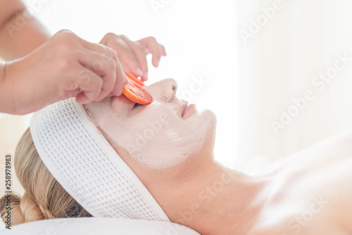 Beautiful young woman relaxing with hand massage at beauty spa. Face massage and spa. Closed up of young beautiful woman getting spa massage treatment at beauty spa salon.