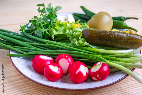 radish, parsley, onion, pickled cucumber and other vegetables on a plate