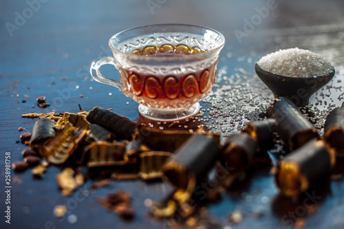 Golden shower tree or garmalo or Amaltas or Cassia fistulatea in a transparent glass cup along with sugar on wooden surface used in the treatment of constipation. photo