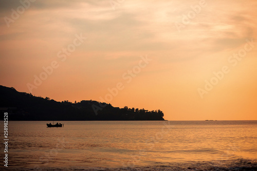 Thailand sea in evening with sun set and small boat in the middle the sea during twilight sky