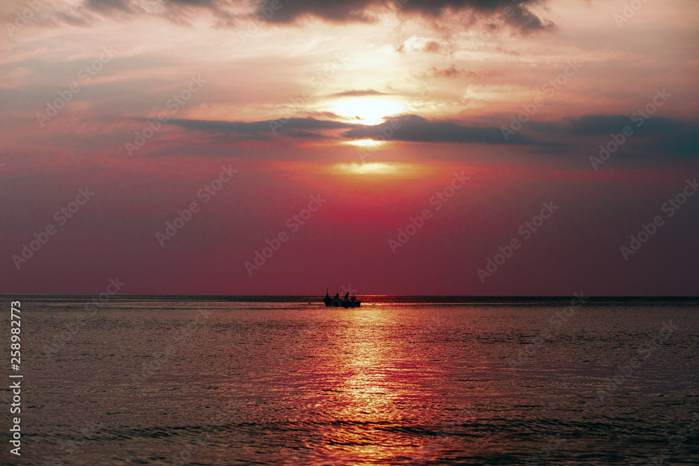 Thailand sea in evening with sun set and small boat in the middle the sea during twilight sky