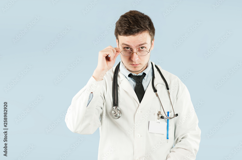 Doctor senior man, medical professional holding something in empty hand isolated over blue background Doctor senior man, medical professional holding something in empty hand isolated over blue background