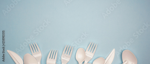 Single-use plastic products  plastic cutlery  cups on bright blue background