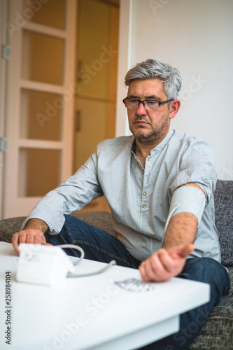 man measuring blood pressure in his home