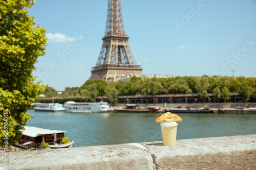 Photography cup of coffee and croissant on the parapet against Eiffel tower