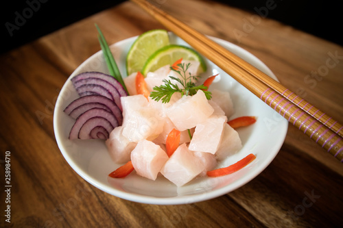 Ceviche bow on wood background. Raw fish with onions, lime and red pepper.