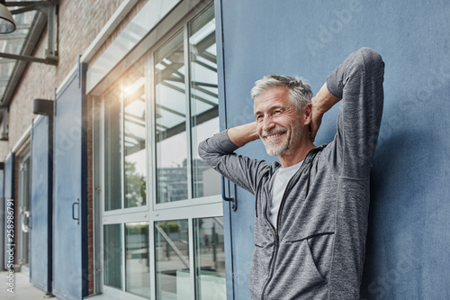 Portrait of laughing mature man in front of gym photo