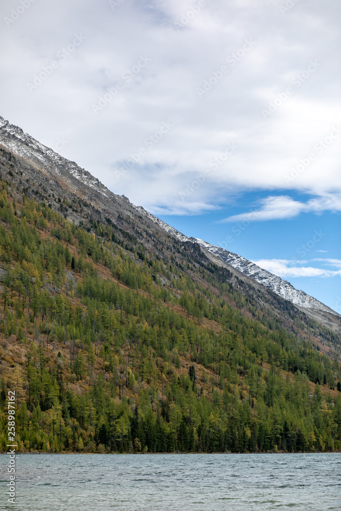 landscape with mountains, green trees and blue lake on a cloudy sky background Altai landscape with mountains, green trees and blue lake on a cloudy sky background Altai