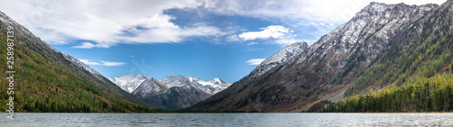 landscape with mountains, green trees and blue lake on a cloudy sky background Altai. Panorama © Semachkovsky 