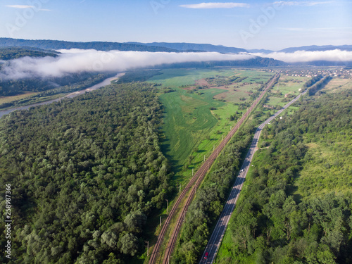 aerial view road with railway station in mountains with forest