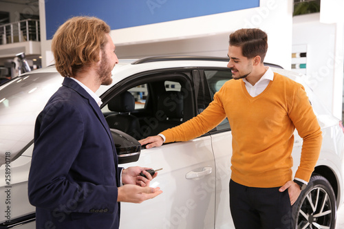 Car salesman working with customer in dealership