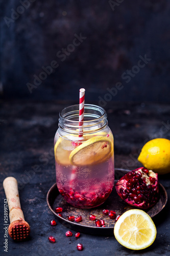 Fruit infused water with lemon slices, crushed pomegranate seeds and sparkling water