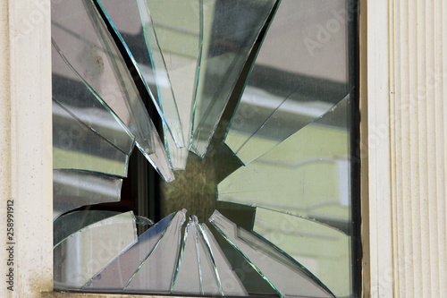 square window with broken glass by stone like star closeup photo