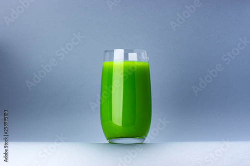 Glass of green juice isolated on white background with copy space for text, fresh apple and celery cocktail