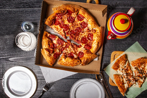 Peperonni pizza. Open pizza box on the table. Pizza delivery. Laid table. Food. photo