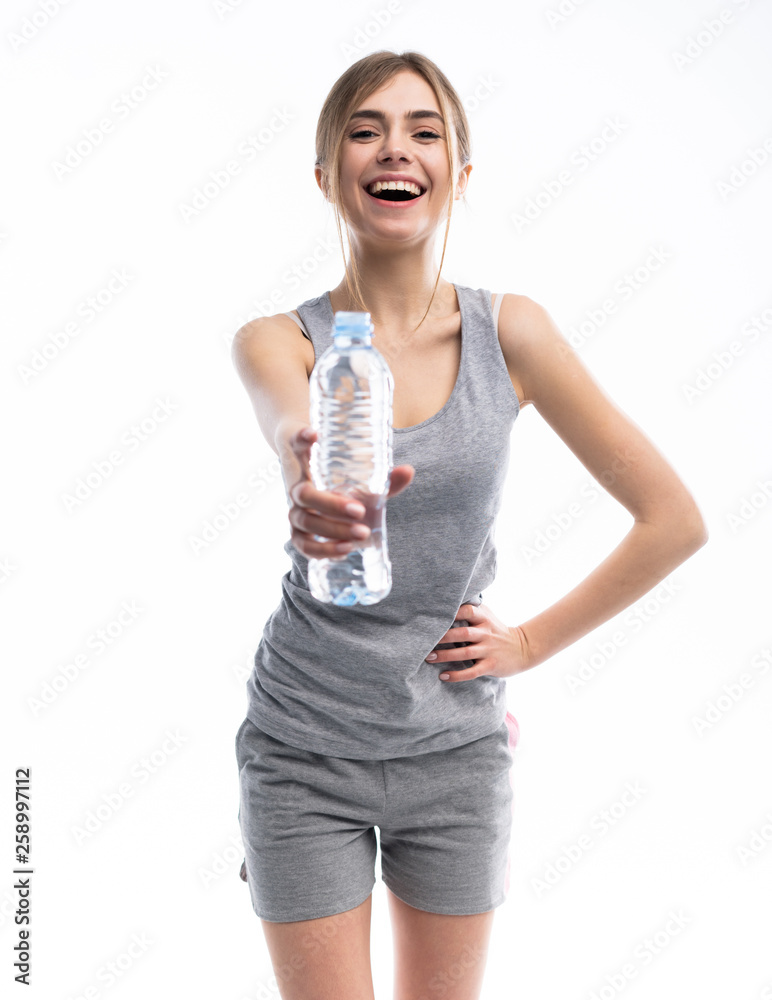 Female fitness model holding a water bottle in a white studio environment. Female fitness model holding a water bottle in a white studio environment.