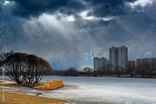 Photography Urban houses and sky with clouds reflected in puddle from melting snow on street