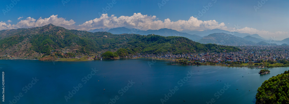 A panoramic view of Pokhara in Nepal with mountain range behind the clouds