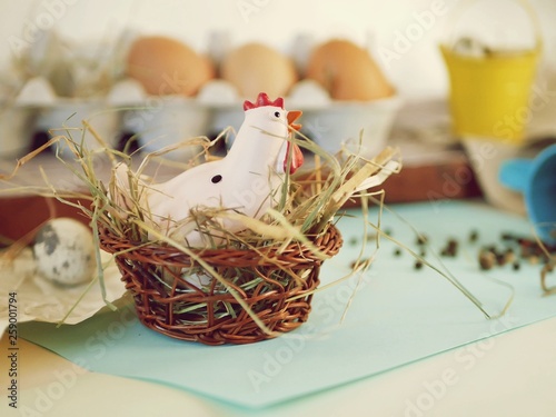  toy chicken, eggs, hay, easter decor on a light background