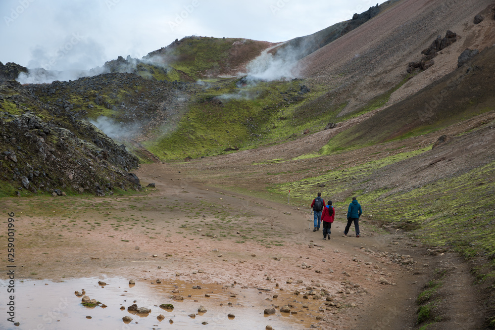 Tourists walking through the steaming mountains of Landmannalaugar