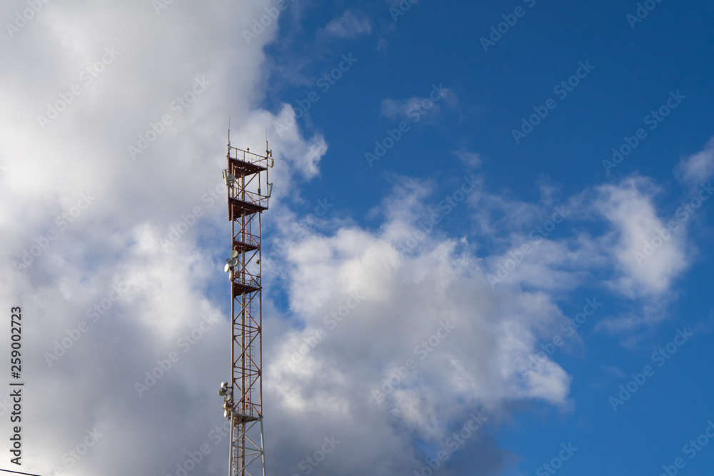 Antenna tower with blue sky and cloud background.