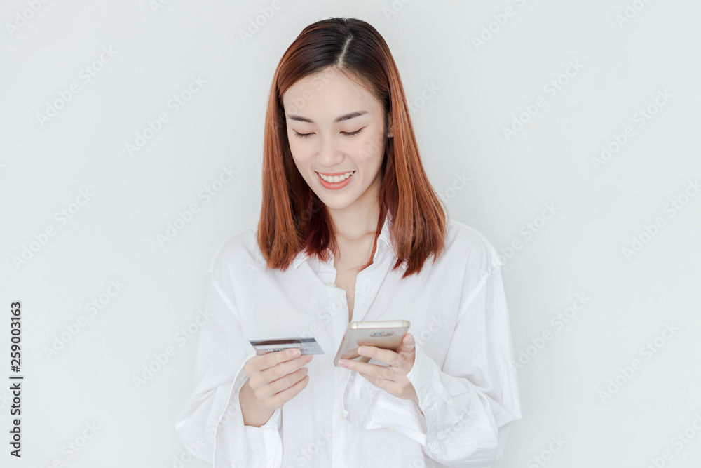 Young woman holding credit card and using mobile phone. Online shopping concept Young woman holding credit card and using mobile phone. Online shopping concept