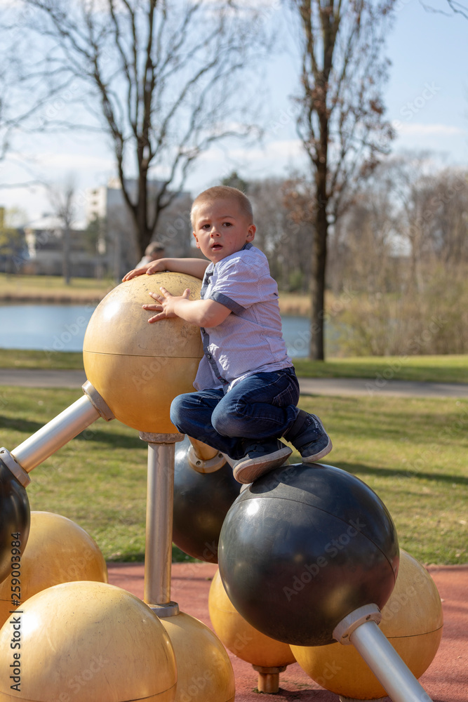 Fototapeta premium Portrait of a little blond boy on playground