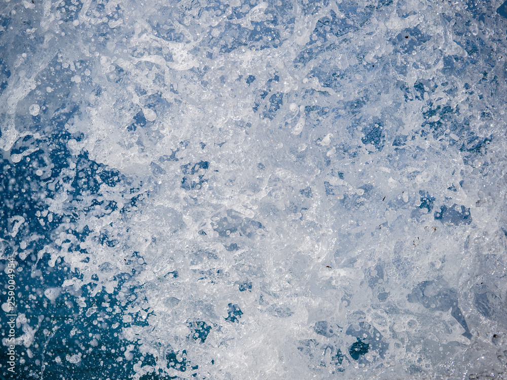 Splashes of water against the sea on a sunny summer day