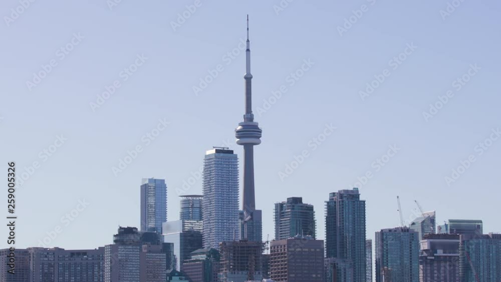 Slow zoom in on the CN Tower and tops of nearby skyscrapers on sunny day in Toronto. Slow zoom in on the CN Tower and tops of nearby skyscrapers on sunny day in Toronto.